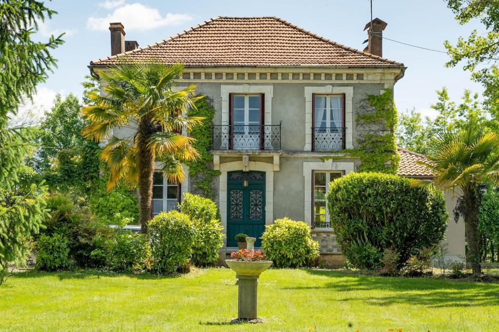 an old house with a palm tree in the yard at Villa Mon But - Maison de maître du 19ème siècle in Hagetmau