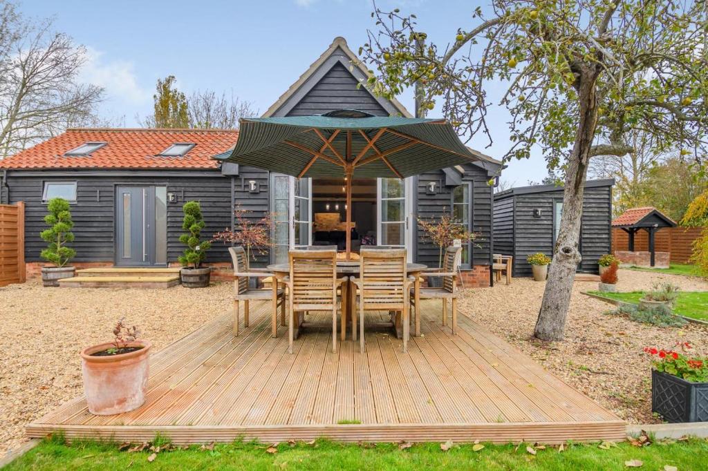een houten terras met een tafel en stoelen voor een huis bij 1 Bed in Dickleburgh oc-m33974 in Dickleburgh