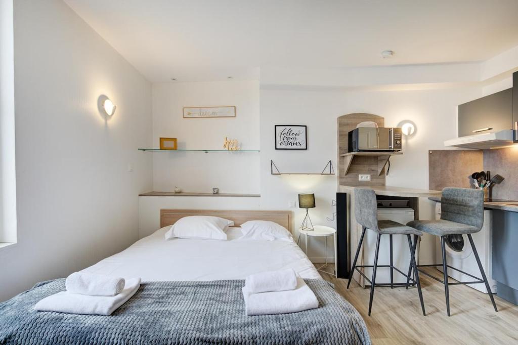ein Schlafzimmer mit Bett und Schreibtisch und eine Küche in der Unterkunft Studio Five - Hyper centre - Proche gare - 2V in Tours