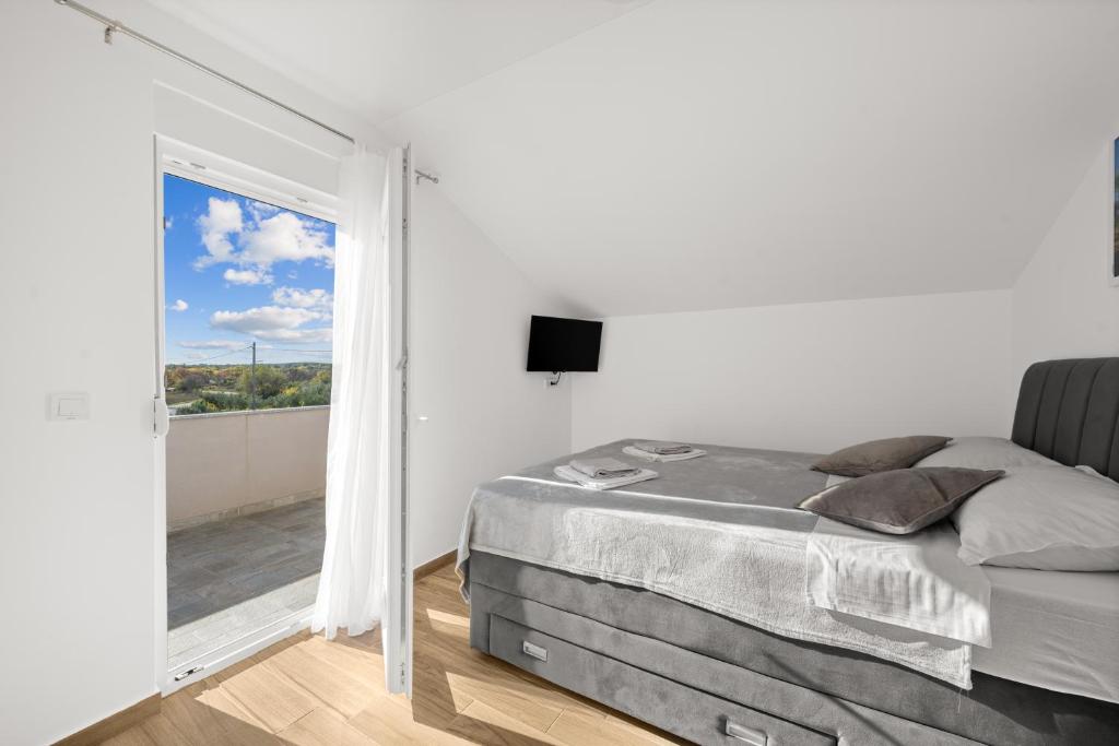 Un dormitorio con una cama y una ventana grande en Kuca za odmor Feniks, en Polača