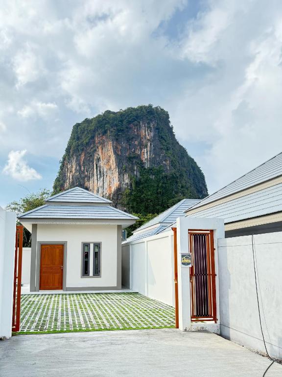 a white house with a mountain in the background at Monkey Pool Villa Krabi Ao Nang in Ao Nang Beach