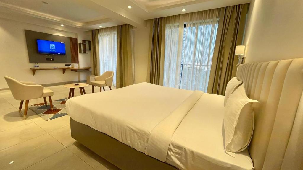 Una habitación de hotel con una cama, una mesa y un televisor. en White Moon, en Lucknow