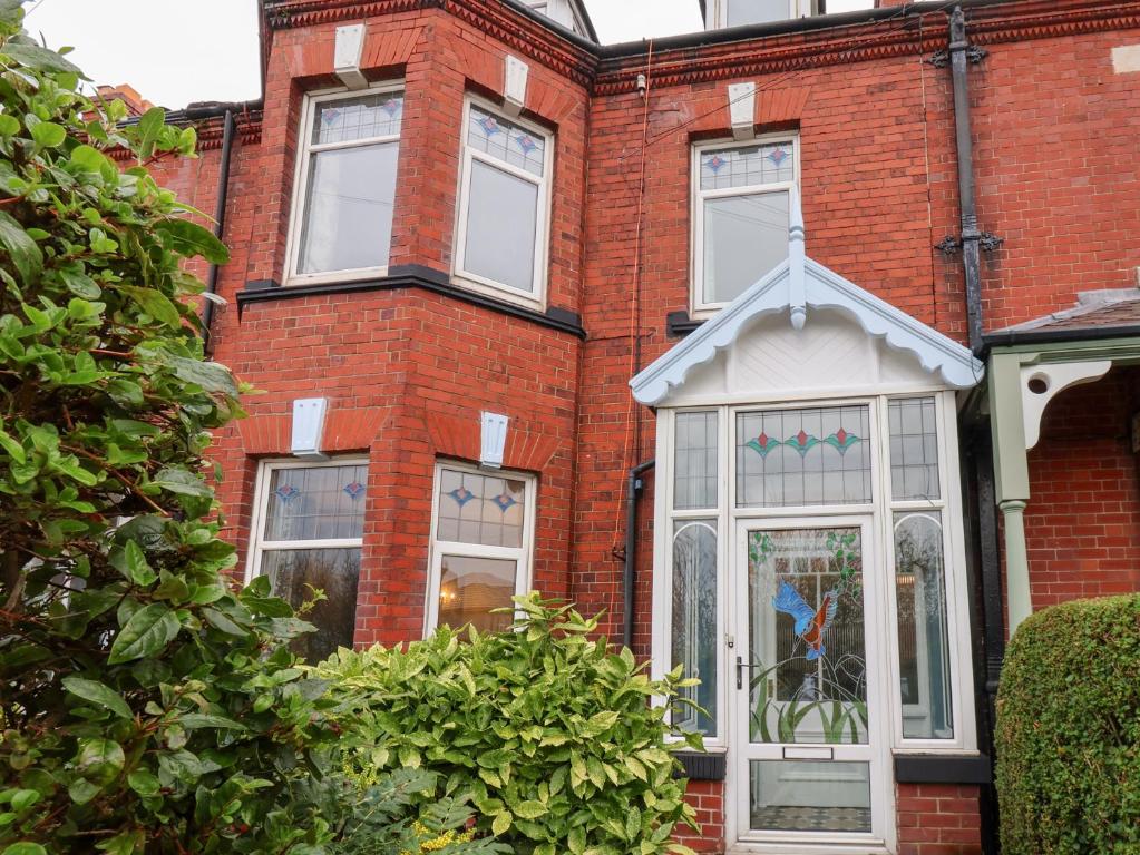 Kingfisher House في ستيثيس: منزل من الطوب الأحمر مع باب أبيض ونوافذ