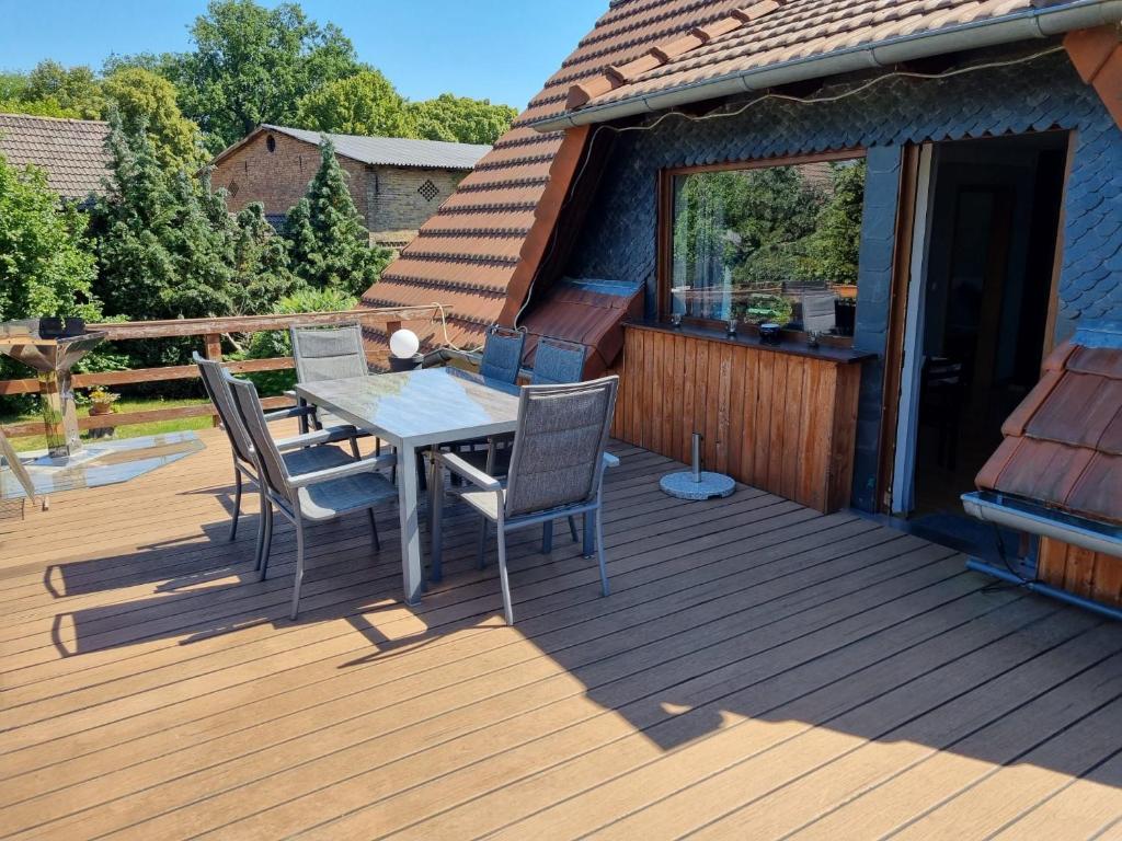 een houten terras met een tafel en stoelen erop bij Ferienwohnung Anna in Schwarz