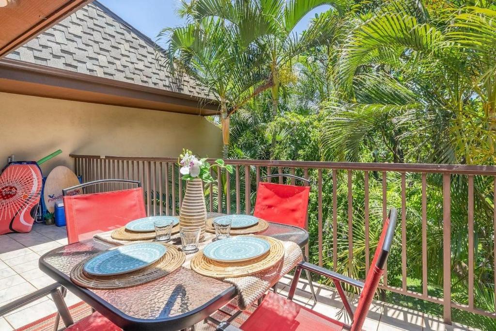 a table and chairs on a balcony with palm trees at Koa Resort 3J · KOA 3J Remodeled 3BD w AC Pool Near Sandy Beach in Kihei