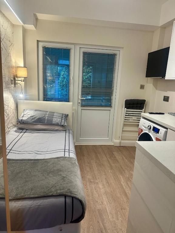 a small room with a bed and a kitchen at Unique space in Edgware in Stone Grove