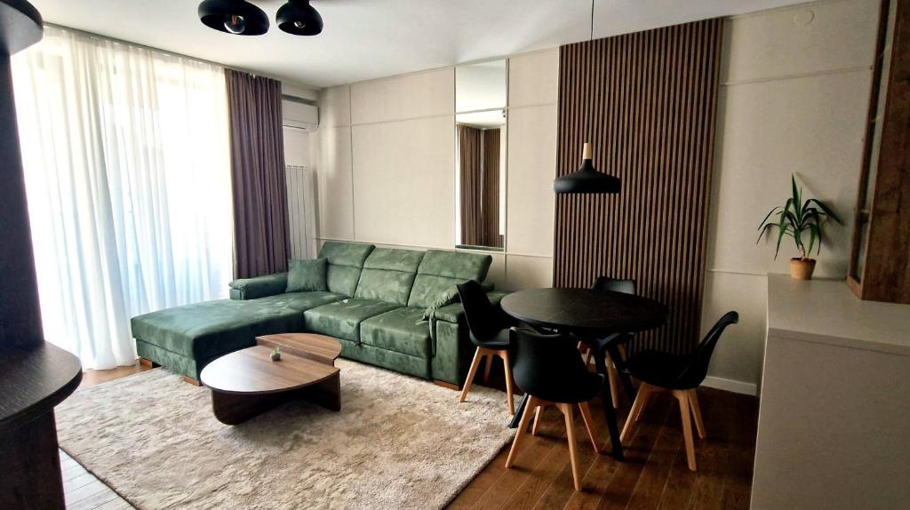 尼什Fluvius Suite - Riverside Elegance in the Heart of Niš with Free Parking的客厅里有一张绿色的沙发和一张桌子