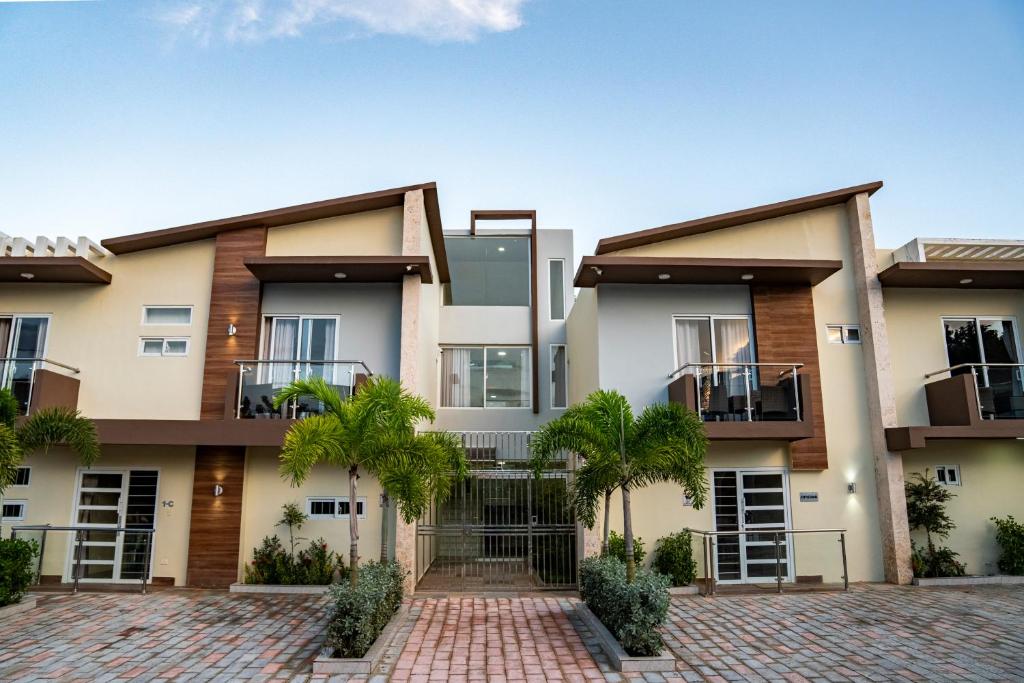 Un edificio de apartamentos con palmeras en frente. en La Isla Royal - Abismo Celeste, en Miches