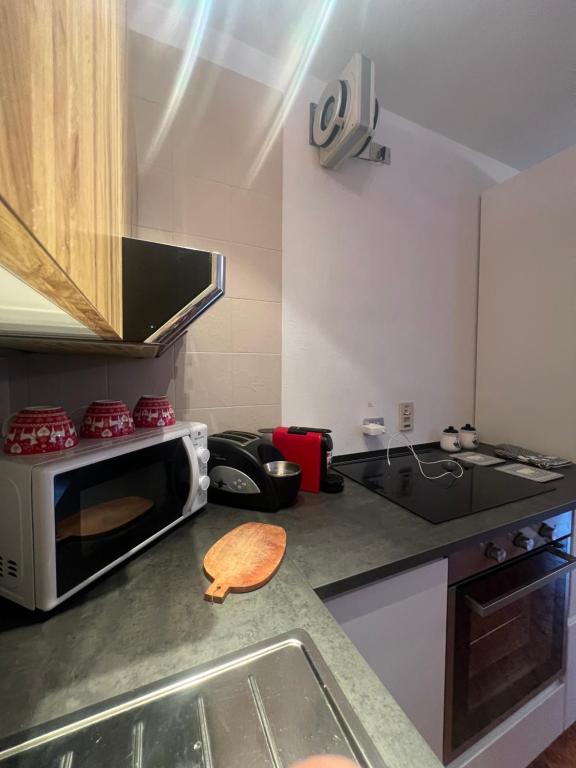 una cocina con encimera y microondas en La Baita Limone Riserva Bianca Ski-in Ski-out Seggiovia Morel 3, en Limone Piemonte