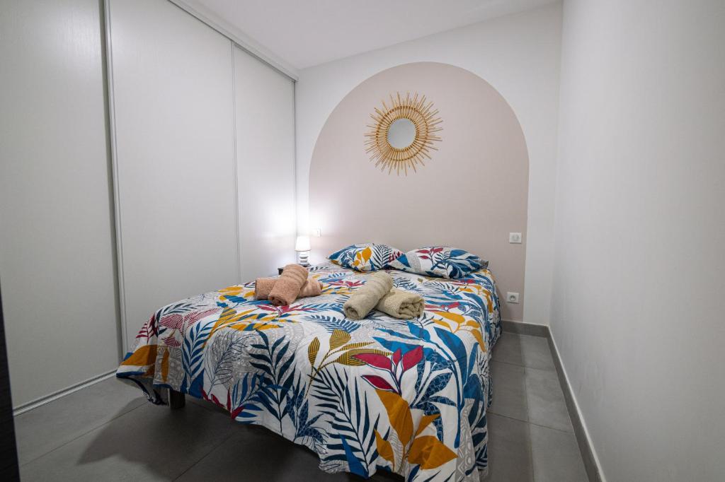 a bedroom with a bed with a colorful blanket at N10 Maison T2 climatisé avec jacuzzi privé in Ajaccio