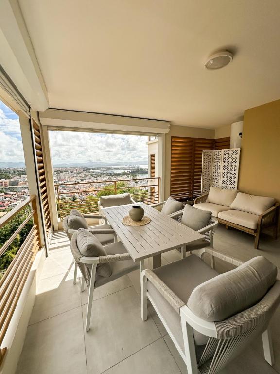 un salon avec une table et des chaises dans l'établissement Appartement Madinina View, à Fort-de-France
