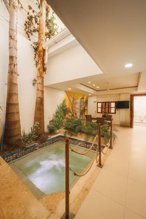 an indoor pool in a hotel lobby with palm trees at Casa gimani Betts in Cartagena de Indias