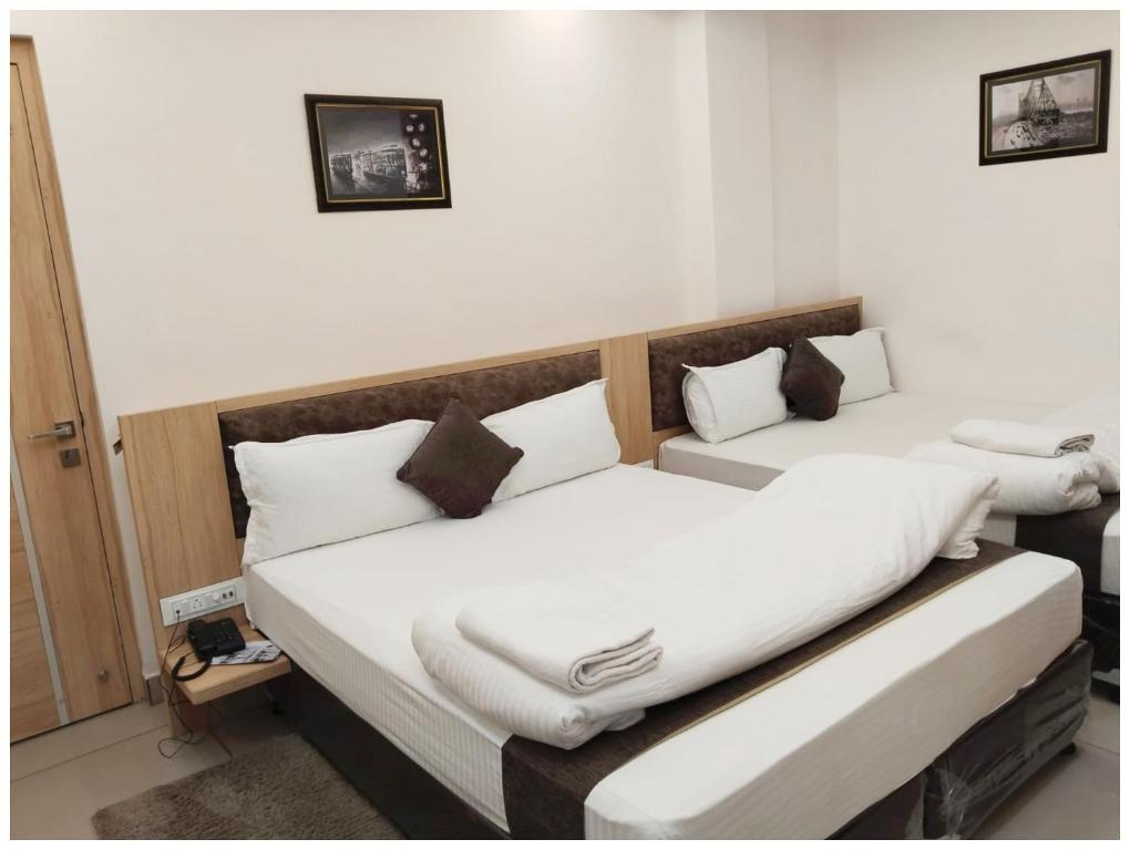 zwei Betten in einem Zimmer mit weißen Laken und Kissen in der Unterkunft HOTEL JEET DIGHA- Sea Beach Prime Location #400M New Digha Beach #Luxurious #Restaurant in Digha