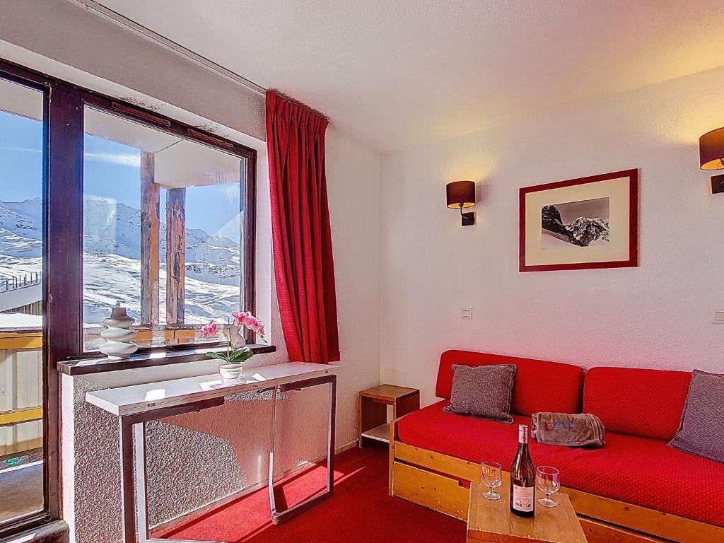a living room with a red couch and a window at Studio Les Olympiades-23 by Interhome in Val Thorens