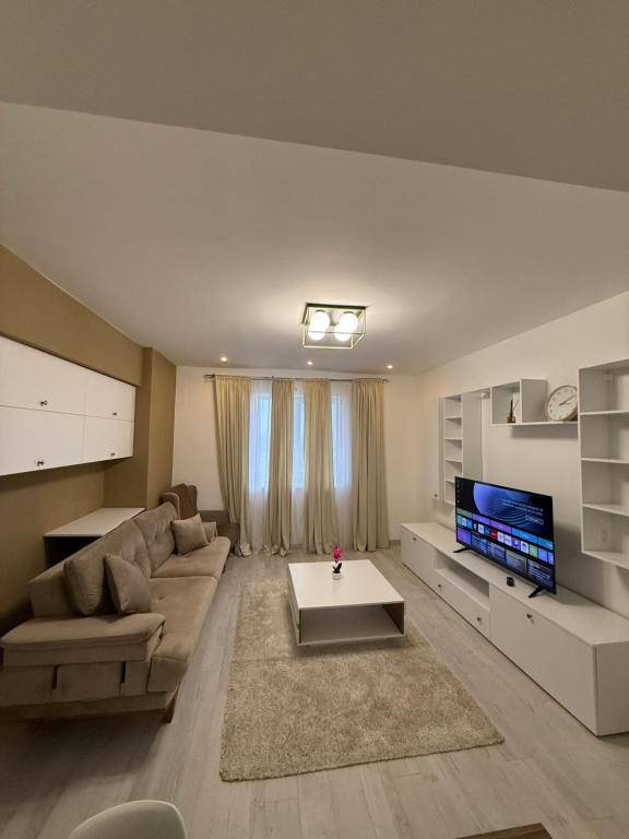 a living room with a couch and a tv at Millo Apartament in Bucharest