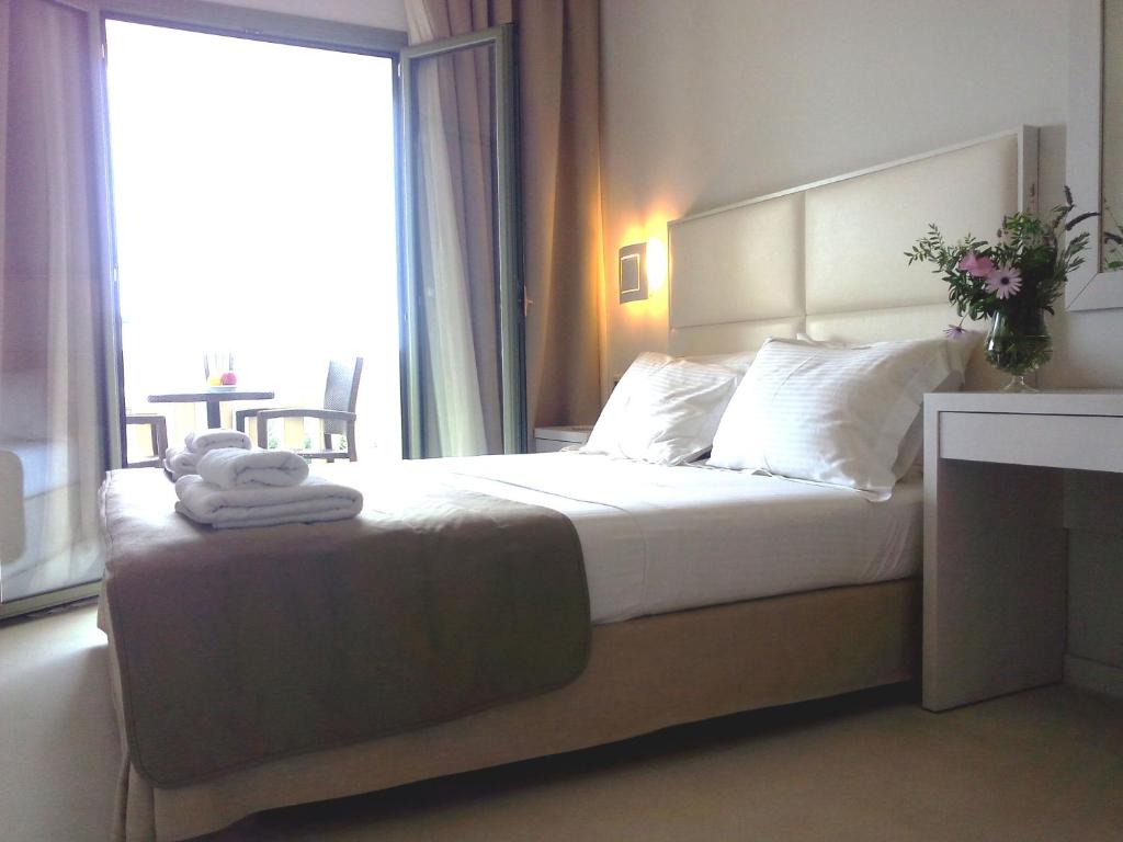 a bedroom with a large bed with a large window at Aphrodite Samos Suites in Marathokampos
