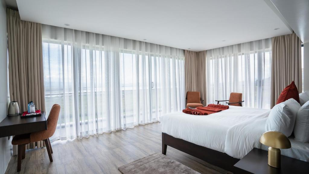 a bedroom with a bed and a desk and windows at The 67 Escape, Elementaita in Gilgil