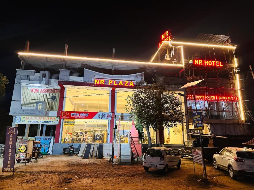 a building with a n pizza sign on it at night at NR Hotel in Rīngas