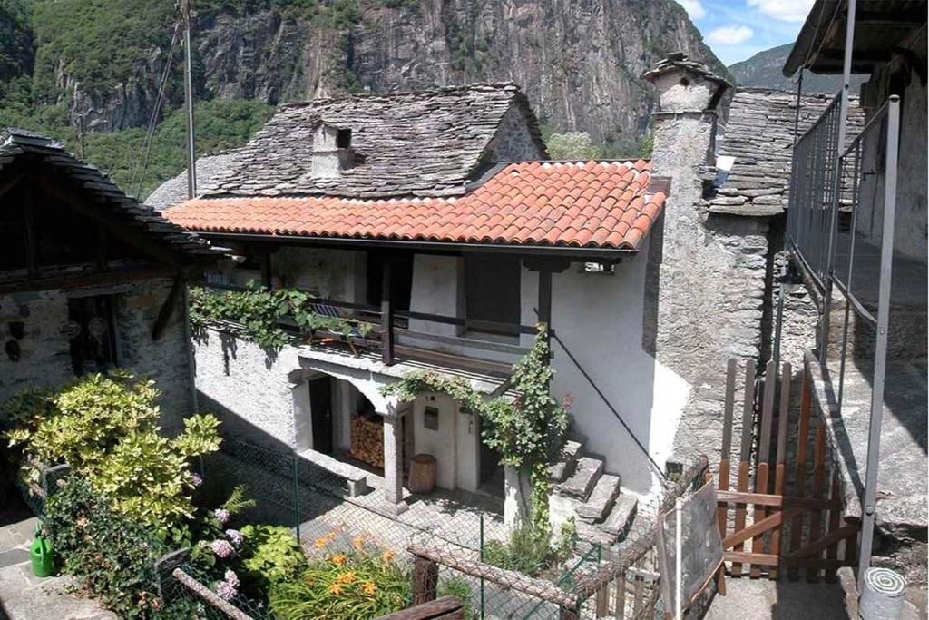 an old house with a mountain in the background at Casa Anna in Avegno