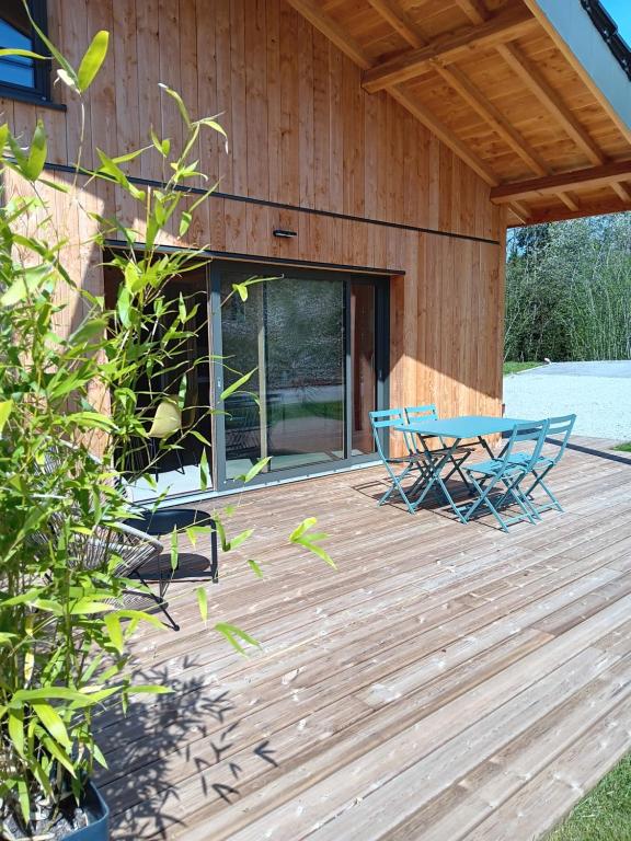 a wooden deck with a table and chairs on it at Gîte Jurassien in Clairvaux-les-Lacs