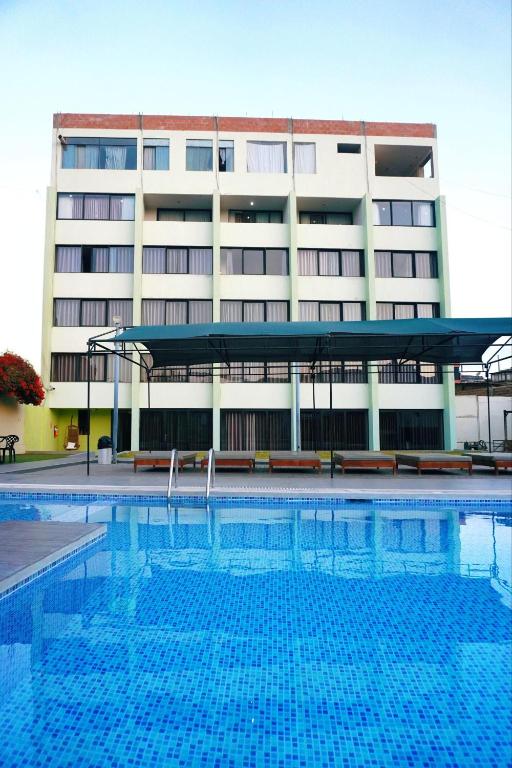 a large swimming pool in front of a building at Holiday Suites in Tacna