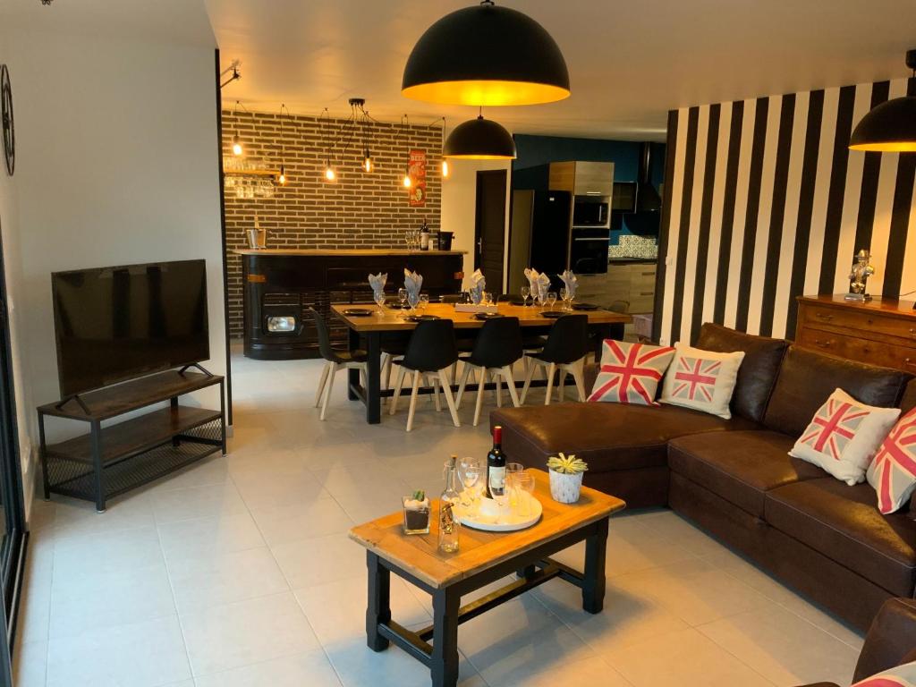 ein Wohnzimmer mit Sofa und Tisch in der Unterkunft L Atelier Veulais in Veules-les-Roses