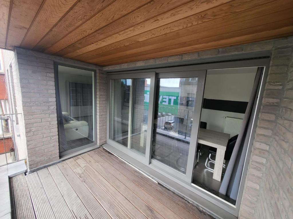 - un balcon avec des portes coulissantes en verre dans un bâtiment dans l'établissement Ruim appartement met terras, à Gand