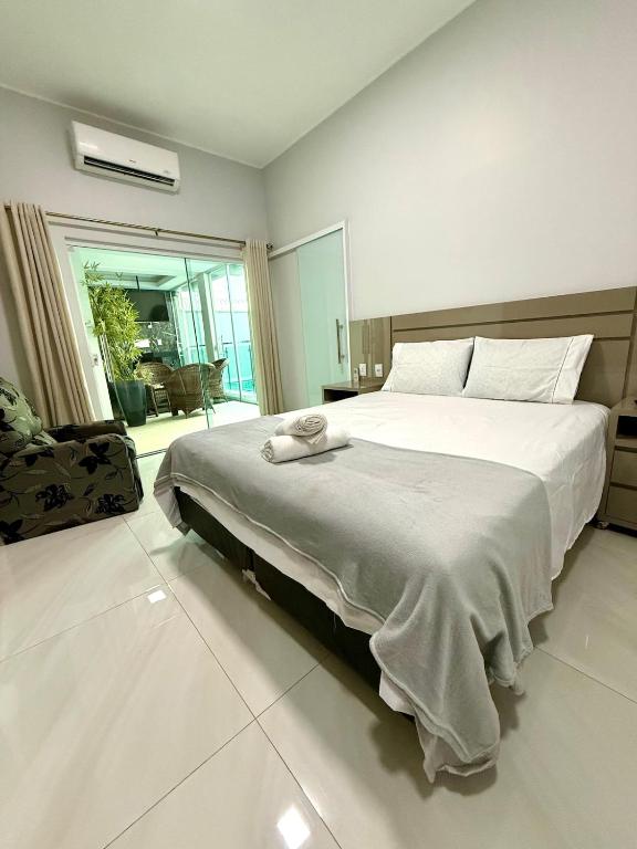 ein Schlafzimmer mit einem großen Bett in einem Zimmer in der Unterkunft Casa Luxo, 3 Qt, Piscina, 2 Vaga, e Área Gourmet in Palmas