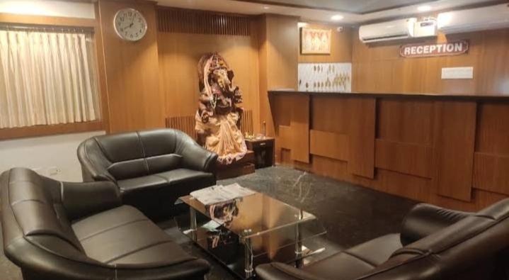 - une salle d'attente avec deux chaises, une table et une horloge dans l'établissement Marquis Beach Resort, à Candolim