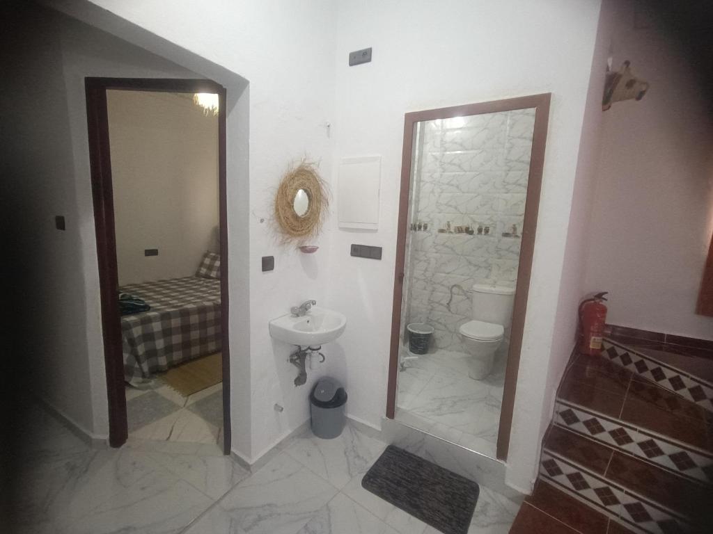 a bathroom with a sink and a toilet and a mirror at Dar lkbira Azazoul in Taghazout