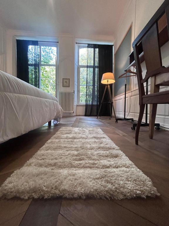 a bedroom with a bed and a white rug at la maison des dames in Poussay