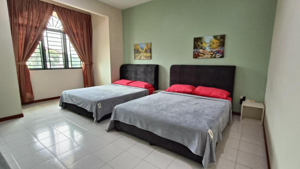 ein Schlafzimmer mit zwei Betten und einem Fenster in der Unterkunft Warisan Indah Homestay KLIA 2 Melayu sahaja in Sepang