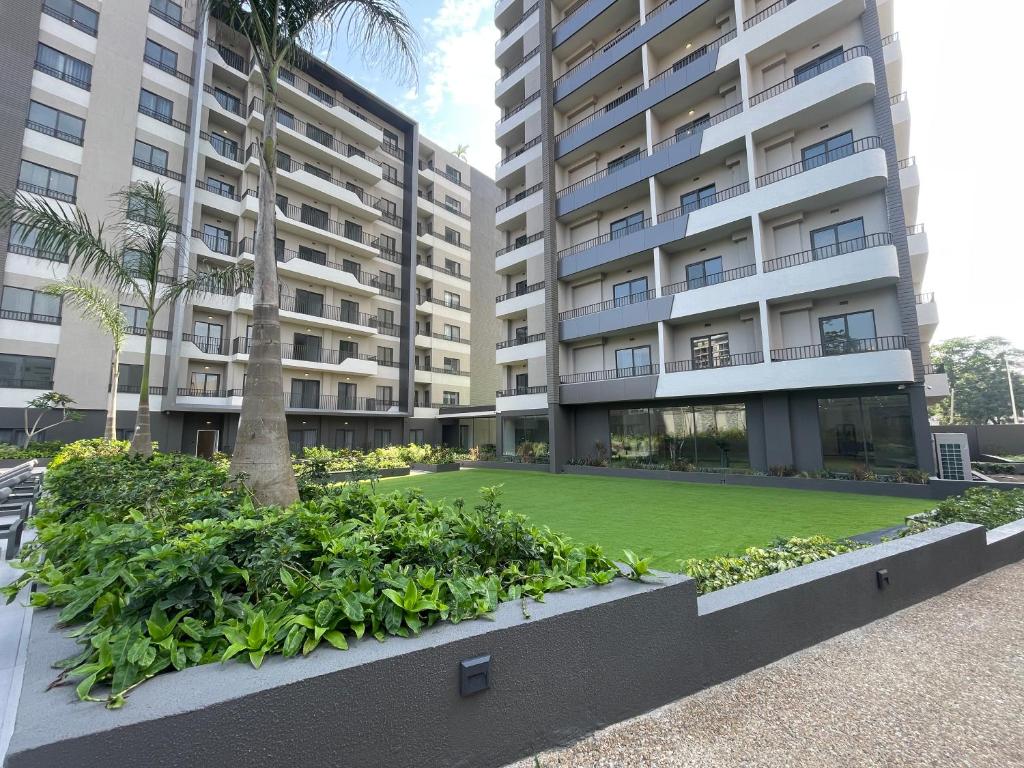 a large apartment building with a lawn in front of it at The Bantree D-plus Apartments in Accra
