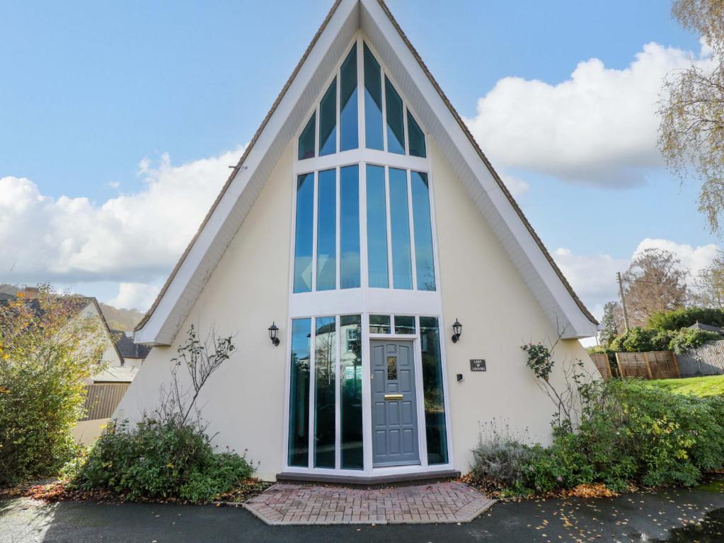 a church with a pointed roof and a glass door at Lady Of Lourdes in Whitchurch