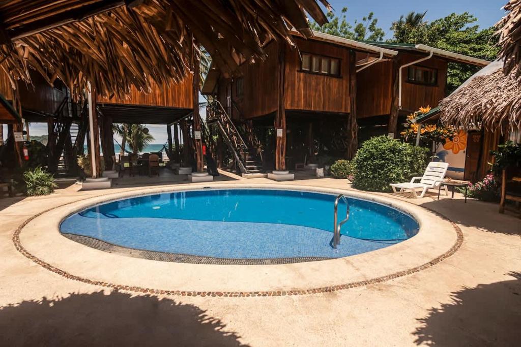 une piscine au milieu d'un complexe hôtelier dans l'établissement Samara Tree House Inn Unit 4, à Sámara