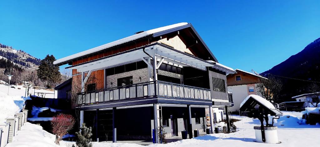 兰格尔斯道夫Konis Ferienwohnung的一座带阳台的雪地建筑