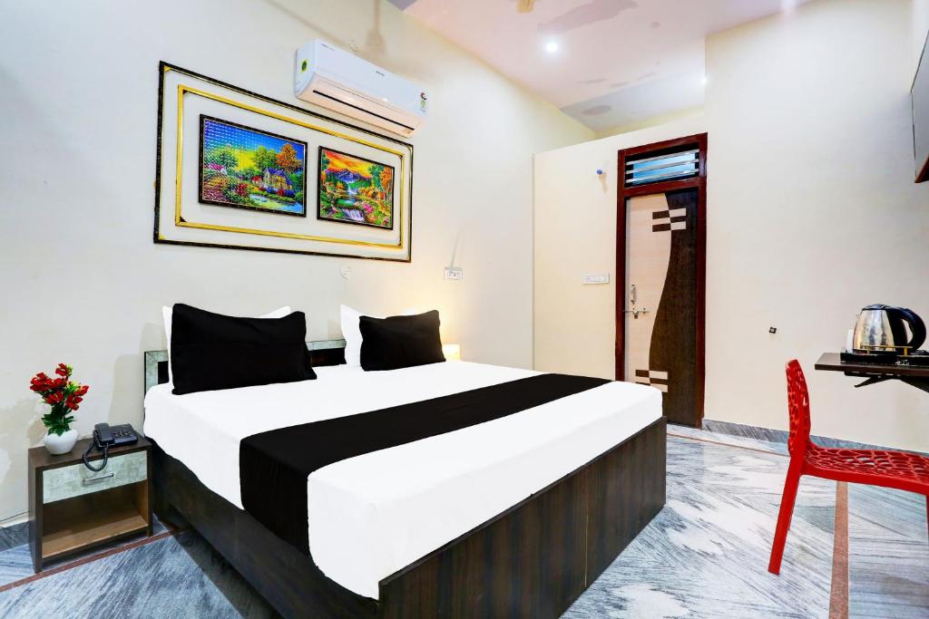 Un dormitorio con una cama y una silla roja. en Hotel O swarnim hotel, en Neemrana