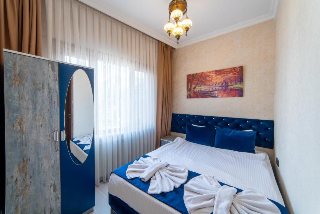 Un dormitorio con una cama azul y blanca y un espejo en Boutique Sultan Hotel, en Estambul