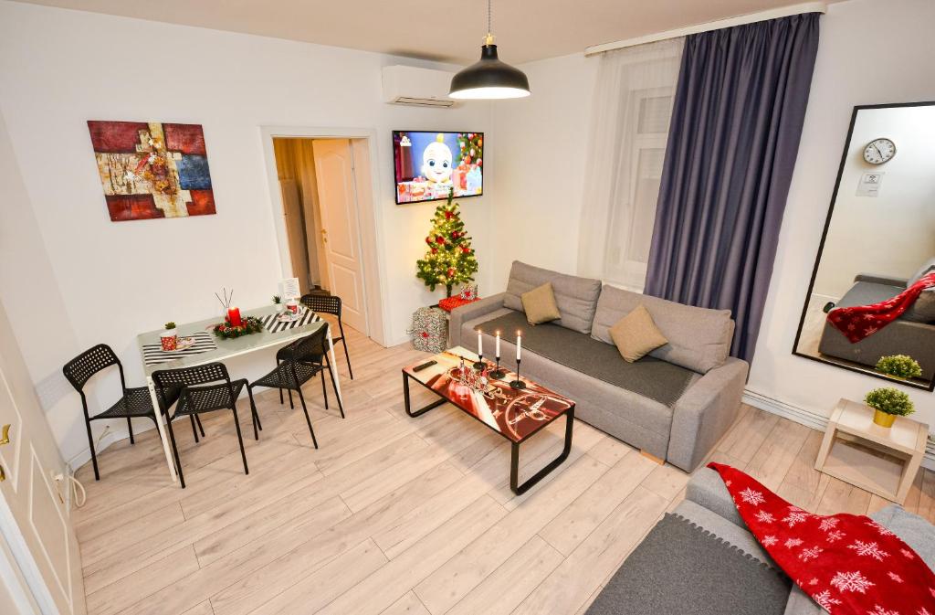 een woonkamer met een bank en een tafel bij Bucharest Christmas Decorated City Center Villa in Boekarest