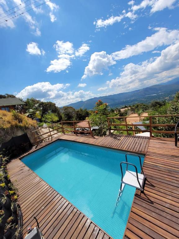 a swimming pool on top of a wooden deck at Cabañas de la loma in Piedecuesta