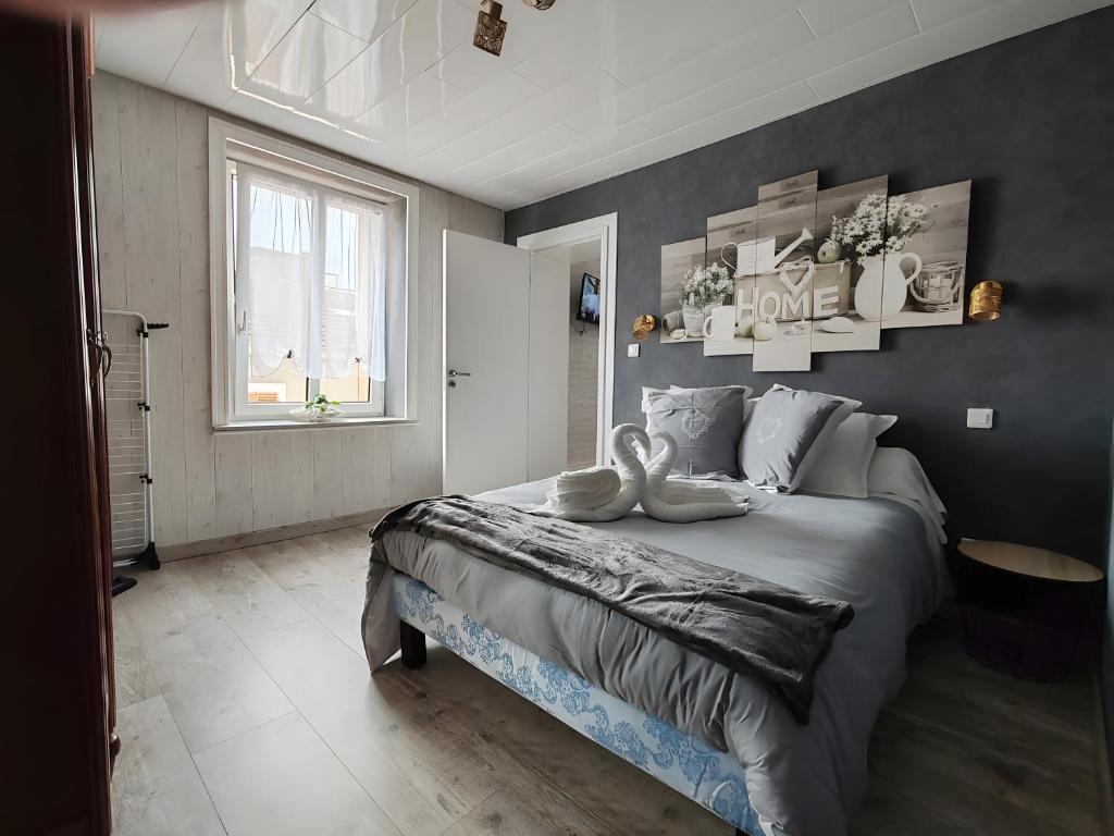 a bedroom with a large bed and a window at Domaine Du Bouleau - Meublé T2 in Bains-les-Bains