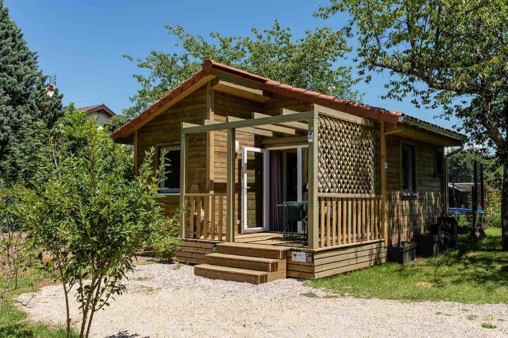 a small log cabin with a porch and stairs at Lodge Natura in Ambérieu-en-Bugey