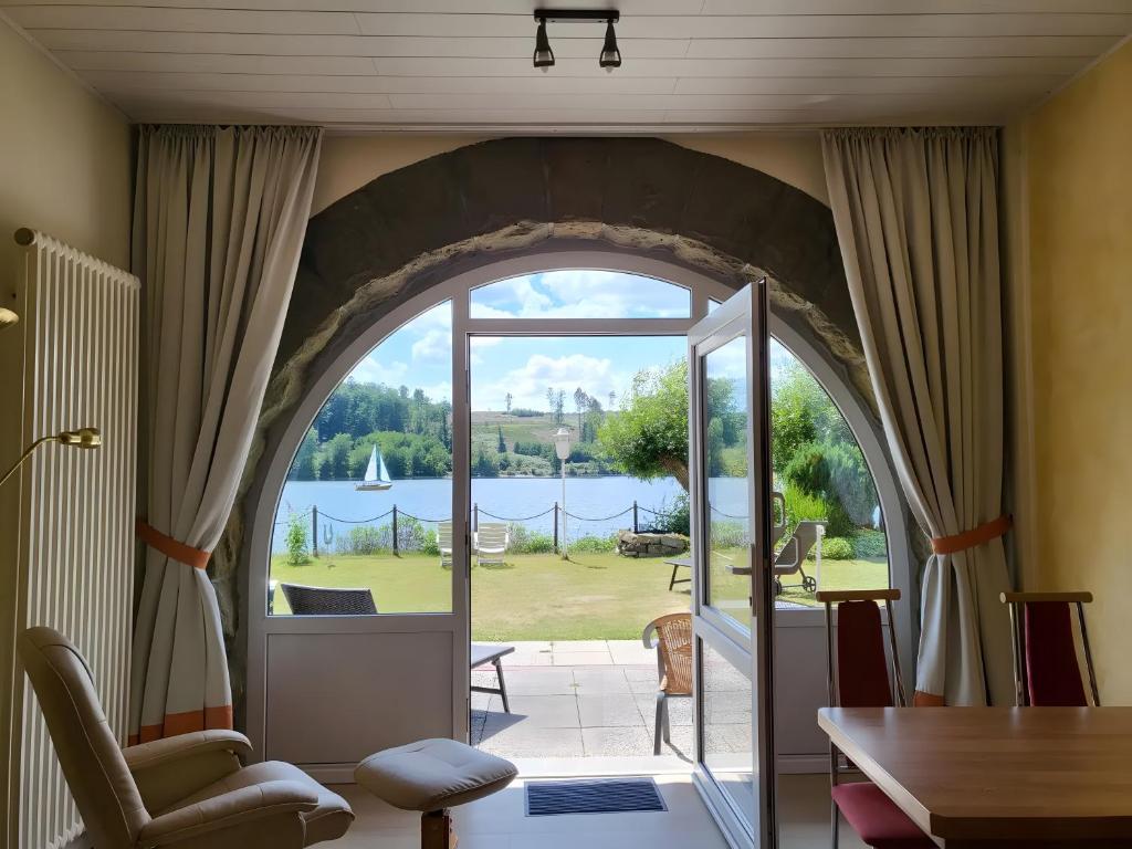 une arche dans un salon avec vue sur l'eau dans l'établissement Strandhof Möhnesee, à Wamel