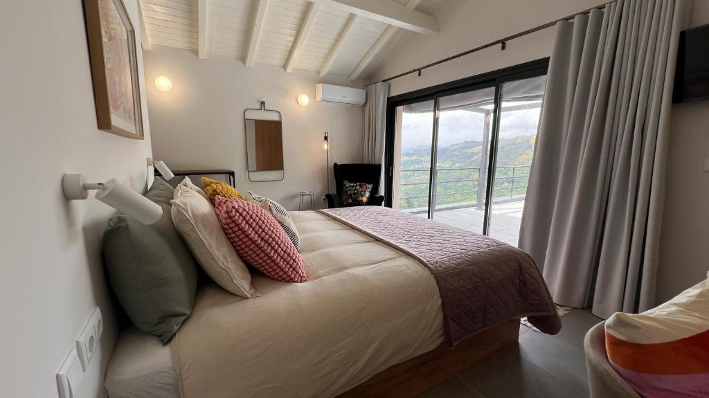 een slaapkamer met een bed met een groot raam bij Serena Terrace in Cabeceiras de Basto