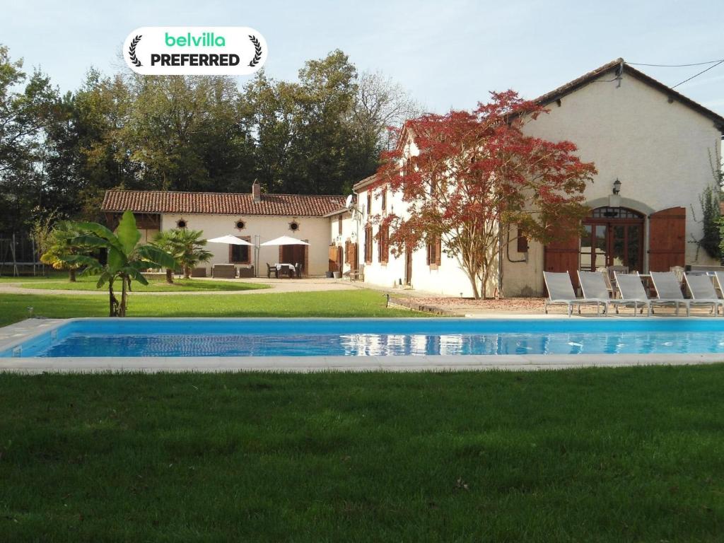 a villa with a swimming pool in front of a house at Luxurious holiday home with private pool in Buzon
