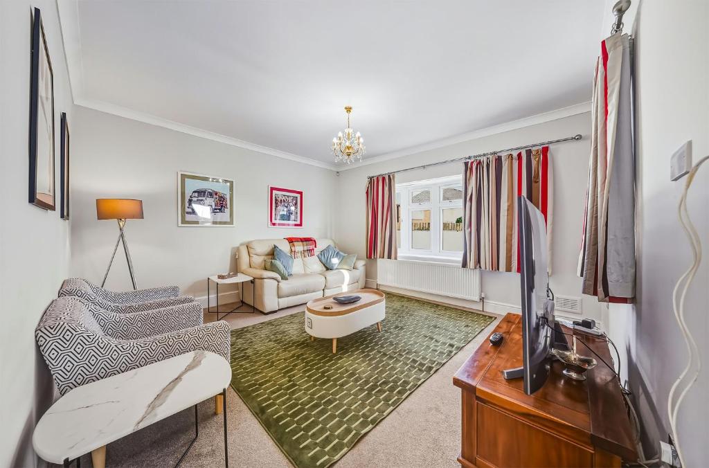 a living room with a tv and a couch at Nancy's 3 bedroom house near Heathrow Airport in Hounslow
