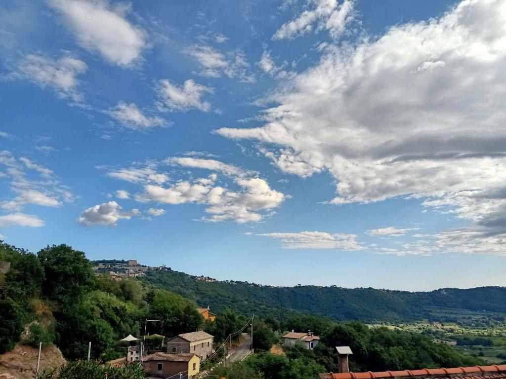 a blue sky with clouds over a village at Le coste sul lago in Montefiascone
