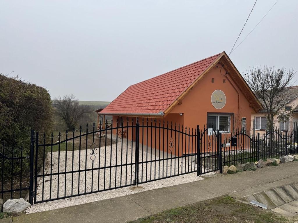 a house with a black fence and a red roof at De Hongaarse Vallei in Szellő