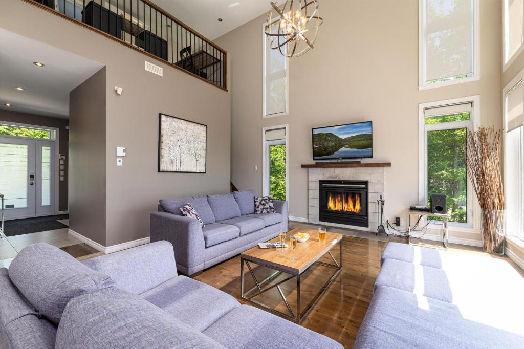a living room with two couches and a fireplace at Phoenix 75: River view, Spa and Pool Table in Petite-Rivière-Saint-François