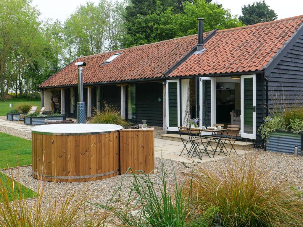 a house with a hot tub in the yard at The Stables - Uk50804 in Cratfield